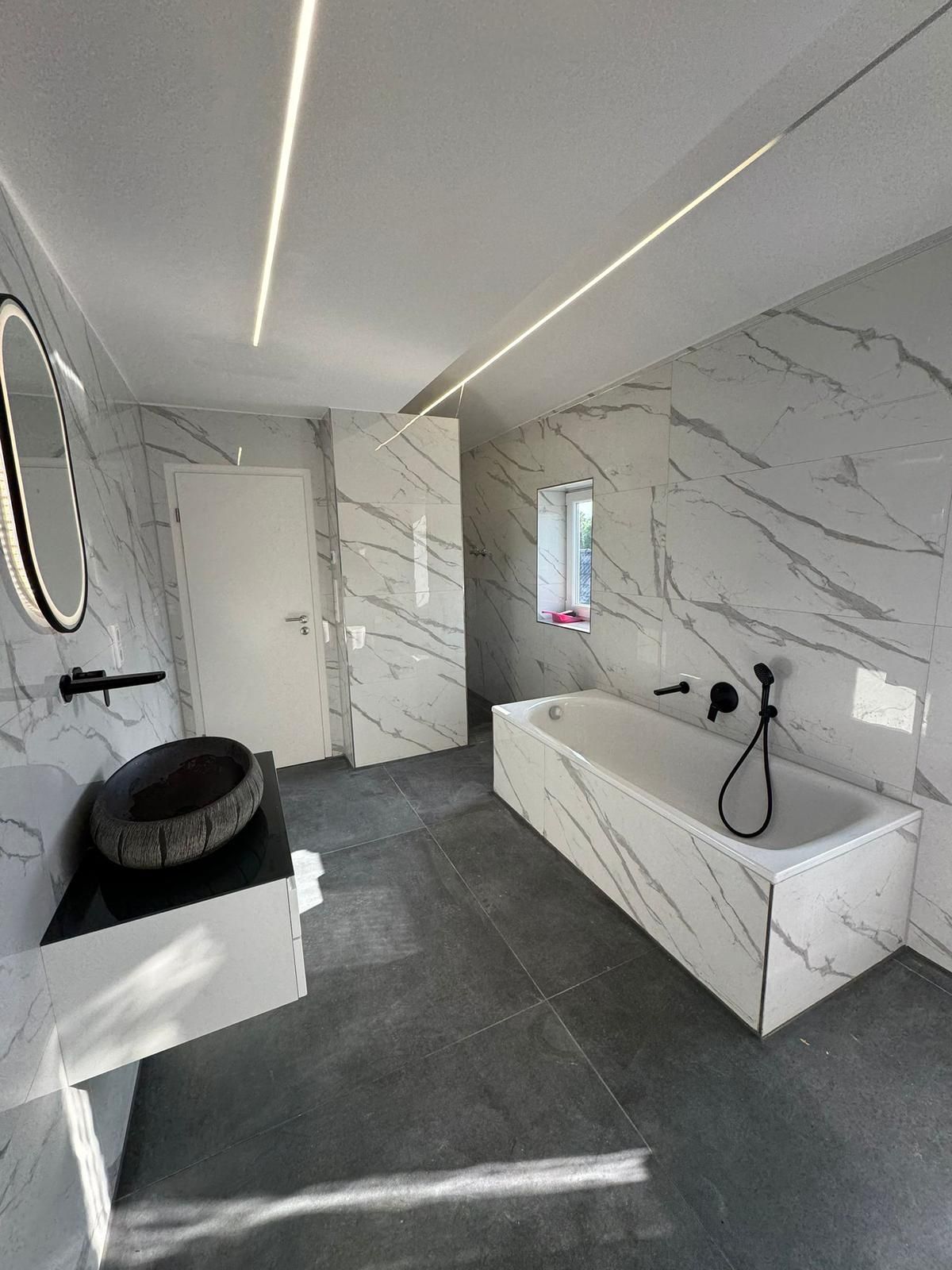 Modernes Bad in Marmoroptik mit freistehender Wanne